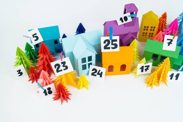 Advent calendar for baby rainbow color. House and Christmas tree paper craft. Christmas holiday decor. White background. Numbers on the label. - 写真・画像