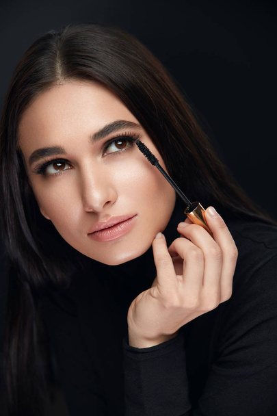 Make-up Kosmetik. Frau mit Schönheitsgesicht trägt schwarze Mascara auf - Foto, Bild