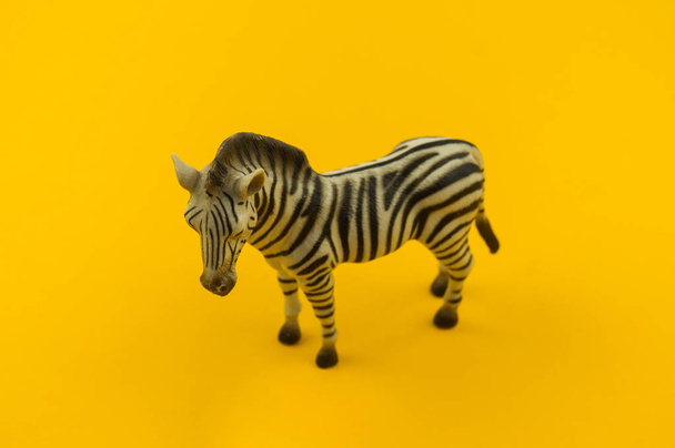 Toy zebra from plastic on a yellow background. African animal for a child. Place to write. - Valokuva, kuva