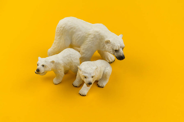 Spielzeug-Eisbär aus Plastik auf gelbem Hintergrund. afrikanisches Tier für ein Kind. Ort zum Schreiben. - Foto, Bild