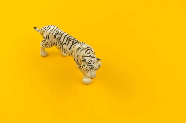 White albino tiger toy made of plastic on a yellow background. African animal for a child. - Fotografie, Obrázek