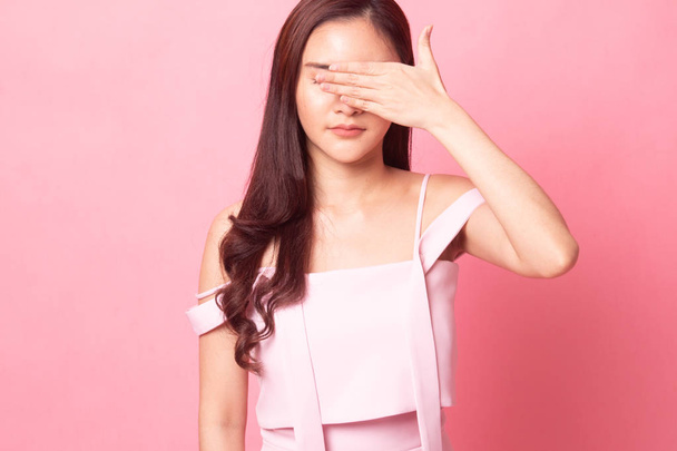 Young Asian woman close her mouth with hand on pink background - Foto, afbeelding