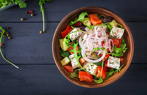 Греческий салат со свежими помидорами, огурцами, красным луком, базиликом, сыром фета, черными оливками и итальянскими травами
 - Фото, изображение