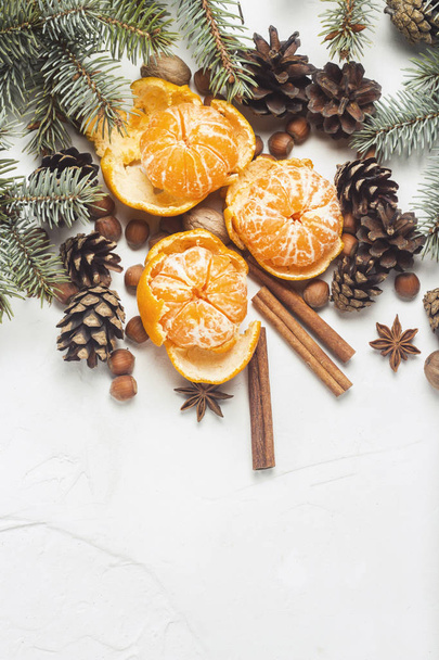 Tangerines without peel, Christmas tree branches, spices, cinnamon, cones on a white stone background. Concept of Christmas, New Year, Mulled Wine. Flat lay, top view - Foto, afbeelding