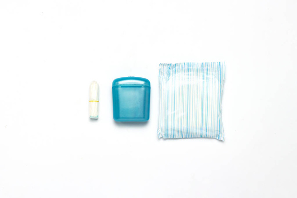 Tampones de higiene femenina, caja para envío y almacenamiento y toallas sanitarias sobre fondo blanco. Concepto de higiene femenina durante la menstruación, elección entre almohadillas y tampones. Piso tendido, vista superior
 - Foto, imagen