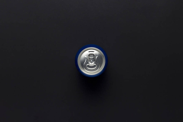 Blikje met drankje op een zwarte achtergrond. minimalisme. Plat lag, top uitzicht - Foto, afbeelding