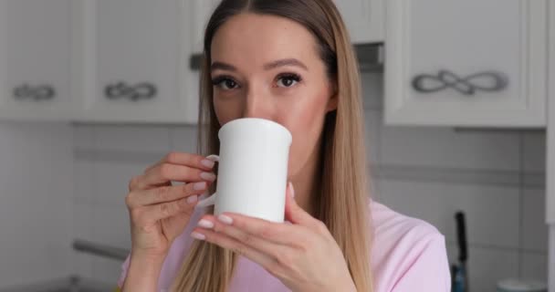 Pembe t-thirt genç kadında zevk evde kış çerez ile çay içme - Video, Çekim