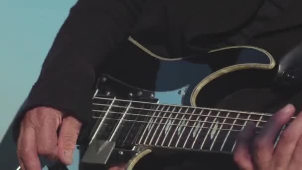 Close-up of old hands of guitarist playing bass guitar. Stock. Masterful performance of playing guitar of old musician. Musical art of playing guitar - Footage, Video