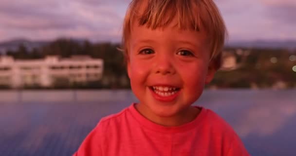 Μικρό αγόρι κοιτάζοντας την κάμερα στο ηλιοβασίλεμα - Πλάνα, βίντεο