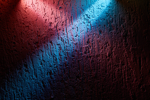 Blauwe lichtbundel overlapt de roze balk op een textuur achtergrond - Foto, afbeelding