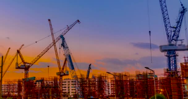Upływ czasu wieczorem zachód słońca, rozwoju żurawie budowlane są pracy i budowanie projektu i zakwaterowanie w mieście biznesu. - Materiał filmowy, wideo
