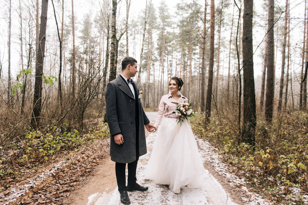 Portrait of happy young lovers of the bride and groom in the forest alley. Wedding day - Fotó, kép