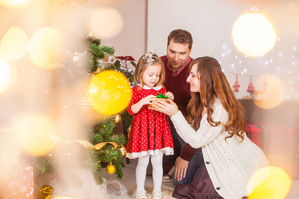 Happy family with daughter open the present on Christmas holiday - Фото, зображення