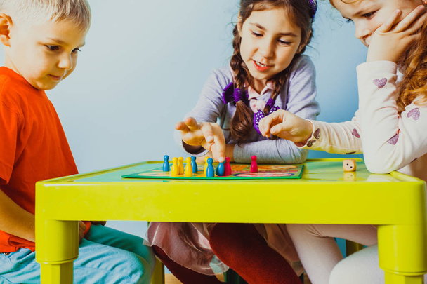 Close view of children faces around table with board game - Φωτογραφία, εικόνα