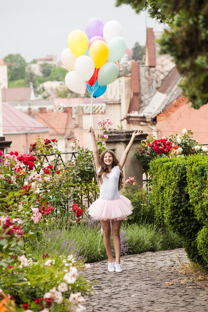 Κορίτσι με πολύχρωμα μπαλόνια latex τρέχει στο πάρκο - Φωτογραφία, εικόνα