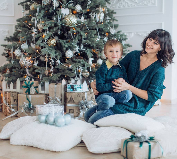 Portrait of happy Mother and Son near Christmas tree  - Fotó, kép