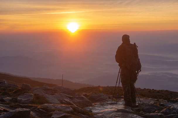 person photographing sunrise on top of mountain - Fotó, kép