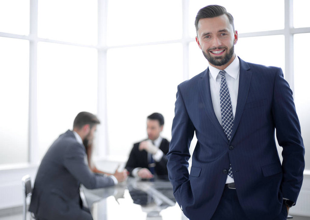 young businessman standing in a bright office - Photo, Image