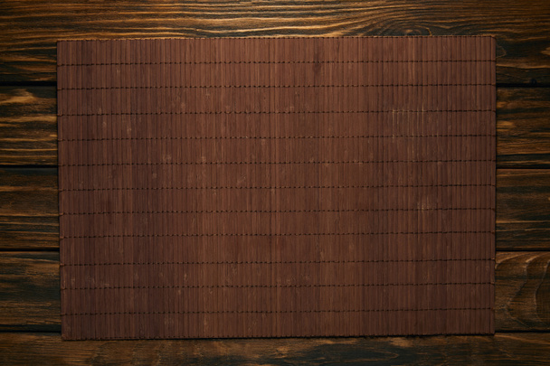 vista dall'alto del tappetino di bambù marrone vuoto sul tavolo di legno
 - Foto, immagini