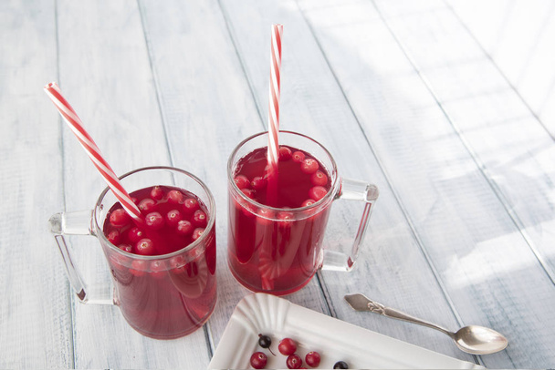 a useful vitamin drink from cranberry, chokeberry, black currant, pear and apple on the wooden table - Photo, image
