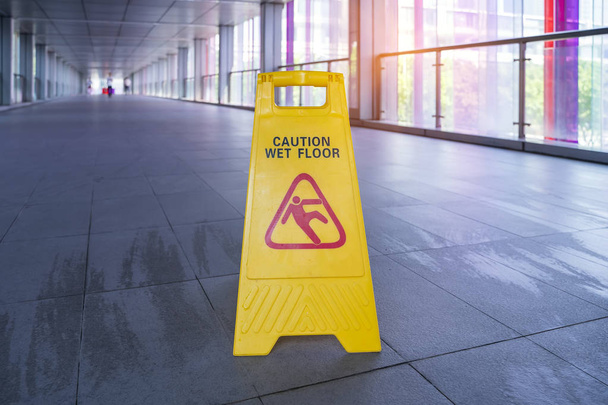 Yellow Caution wet floor sign on wet floor with red bucket - 写真・画像
