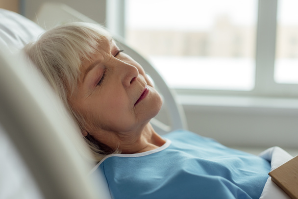 selective focus of senior woman with grey hair sleeping in hospital bed - Foto, Imagen
