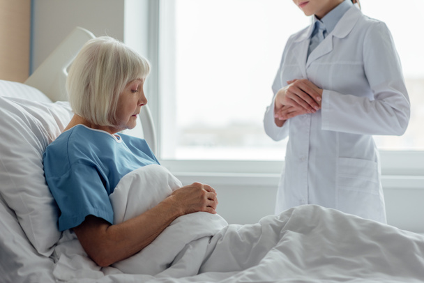 lekarka konsultacji starszy kobieta leżąc w łóżku szpitalnym - Zdjęcie, obraz