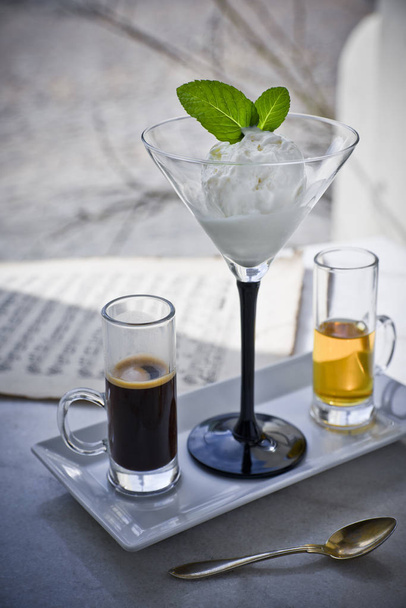 Affogato with with Ice Cream, strawberries, mint leaves, espresso and liqueur on the marble table, musical notes in the background - Photo, Image