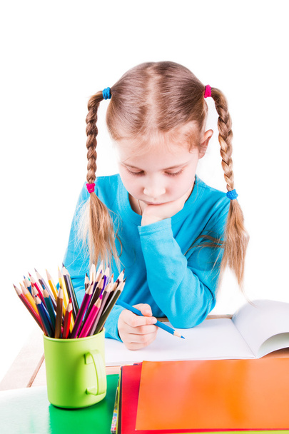 schattige lachende meisje tekenen van een afbeelding in een schetsboek met kleurpotloden - Foto, afbeelding
