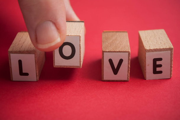 Nahaufnahme des Wortes Liebe in Holzbuchstaben auf rotem Hintergrund - Foto, Bild