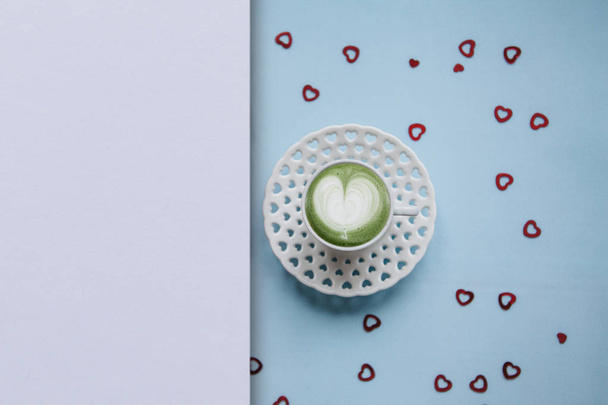 Una taza con un sabroso y aromático café matcha latte de la mañana sobre un fondo festivo
. - Foto, imagen
