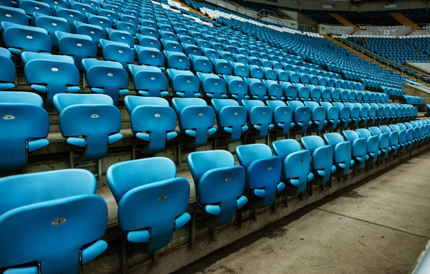 Stadyumun boş eski plastik sandalyeler. Küçük bir eski stadyumda boş koltuk sayısı. Hayranları için çizilmiş yıpranmış plastik koltuk - Fotoğraf, Görsel