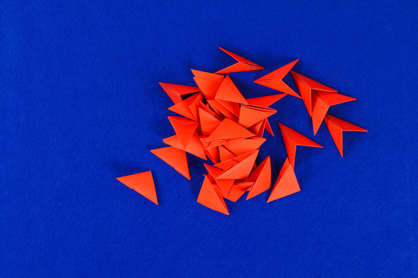 Diy chinese dragon on blue background. Gift ideas, decor Chinese new year. Handmade red gold lunar dragon lion from modular origami. Step by step. The process of crafts. Top view. - Zdjęcie, obraz