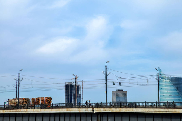 Vista del puente Akmens desde el Embankment del 11 de noviembre. Puente de piedra sobre el fondo azul del cielo en Letonia. Puente que cruza vehículos y peatones. Puente de piedra en la ciudad de Riga. - Foto, Imagen