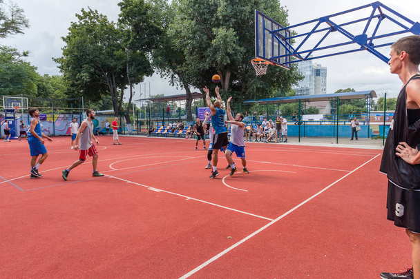 ODESSA, UCRANIA - 28 DE JULIO DE 2018: Los adolescentes juegan baloncesto durante el campeonato de streetball 3x3. Los jóvenes juegan baloncesto callejero en un campo de deportes de la ciudad abierta. Streetball - culturas callejeras
 - Foto, imagen