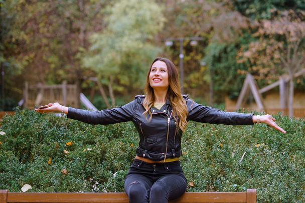 Retrato de una mujer feliz con los brazos extendidos en el parque
 - Foto, Imagen