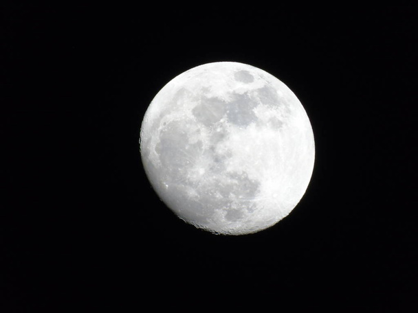 Una fotografía asombrosa de la luna llena sobre la ciudad de Génova por la noche con un gran cielo claro en el fondo y algunas estrellas
 - Foto, imagen