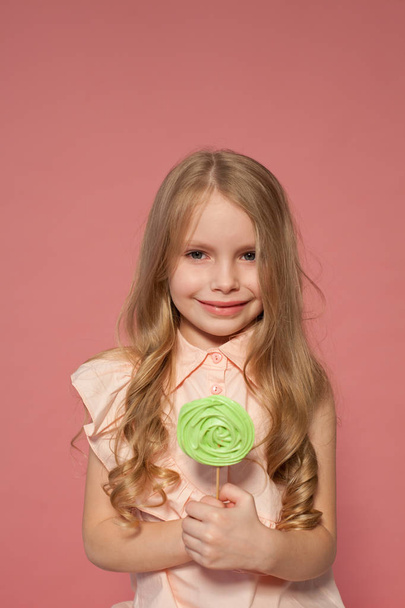 mała dziewczynka jedzenie słodki candy lollipop na patyku - Zdjęcie, obraz