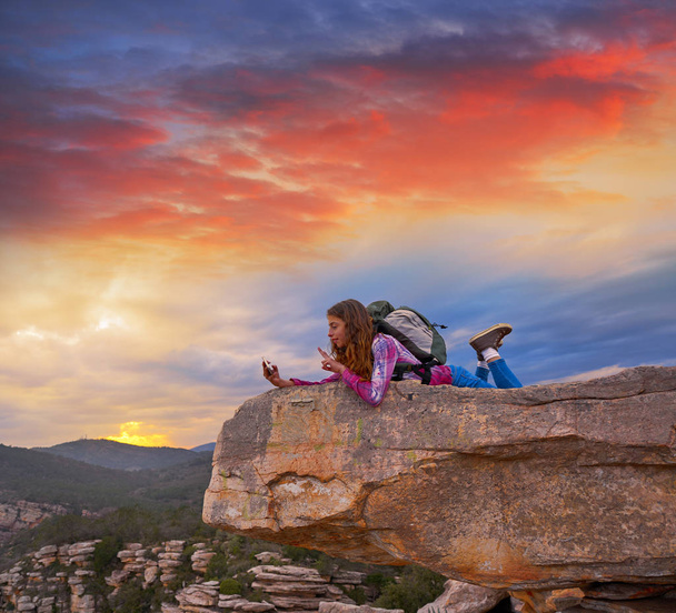 Hiker adolescente chica selfie smartphone en el pico de la montaña al atardecer
 - Foto, Imagen