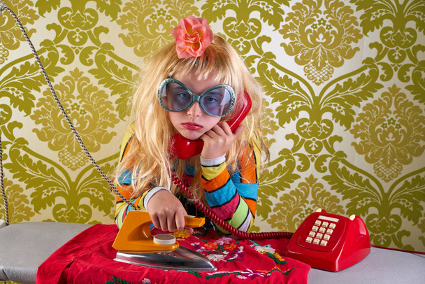 Sad housewife kid girl iron chores talking at red retro phone vintage humor - Fotografie, Obrázek