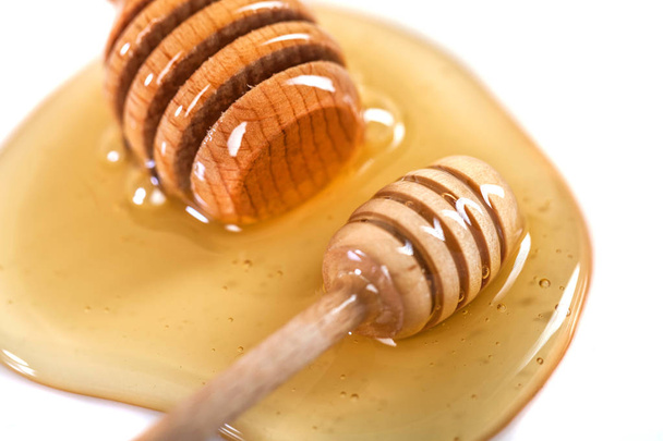 Honey with wooden dipper isolated on white background. - Foto, Bild