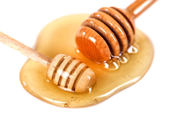 Μέλι με ξύλινη κουτάλα που απομονώνονται σε λευκό φόντο. - Φωτογραφία, εικόνα