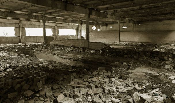 Interieur van de vernietigde gebouwen van de oude fabriek. ruïnes van een industriële onderneming, donkere fragmenten vernietigde fabriek pand aan de plant als gevolg van economische crisis catacomben, kelder, tunnel - Foto, afbeelding