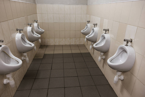 männliches Urinal in einem öffentlichen Männerzimmer. öffentliche Toilette - Komfort männliche moderne Toilette Urinal, weiße Urinale im öffentlichen Hygienesaal der Büroräume - Foto, Bild
