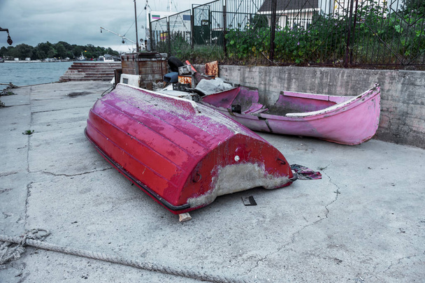 старий покинутий зламаний човен вмирає на березі. Фрагмент старого маленького човна. Іржаве обладнання, колонія мідій на дні човна. Старий пошкоджений човен
 - Фото, зображення