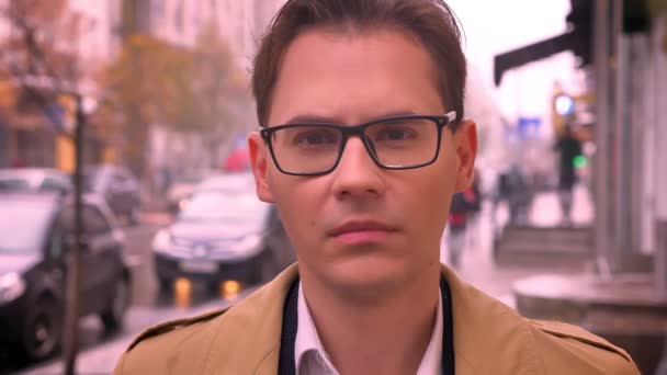 Closeup dospělých kavkazské muži čelí fotoaparátu těší v brýlích, stojící na ulici silnice a auta - Záběry, video
