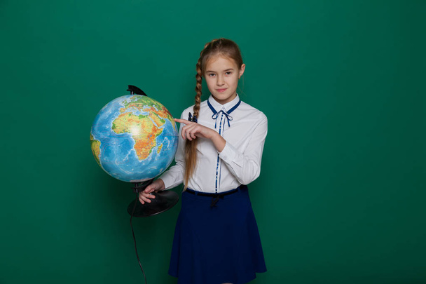 girl with a globe at the Blackboard in a class lesson - Photo, image