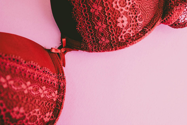 Kaunis punainen pitsi naisten maallinen lempeä rintaliivit, alusvaatteet ja kopioi tilaa vaaleanpunainen, violetti tausta. Litteä
 - Valokuva, kuva