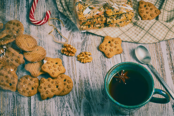 ceramic Cup of black tea with a handful of cookies with nuts on a white, old, shabby wooden table,. the composition of the morning Breakfast with cookies. - Foto, Imagem