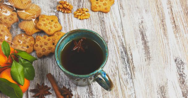 kerámia csésze fekete teát egy maroknyi dióval, egy fehér, kopott, régi fából készült asztal, a cookie-kat. reggel reggeli cookie-k összetétele. - Fotó, kép